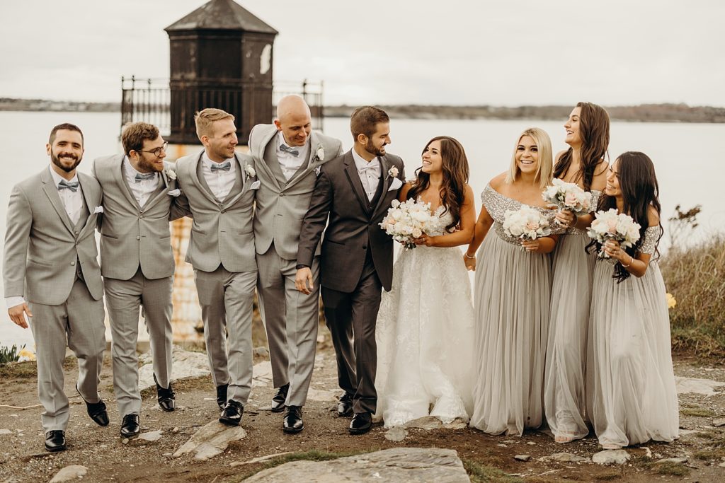 Bride and Groom looking at each other and beginning to walk with wedding party beside them