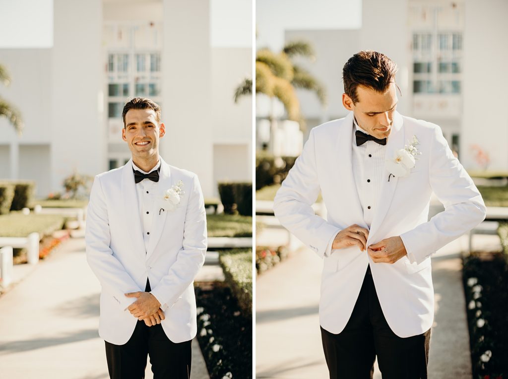 Closeup portraits of Groom in black and white suit buttoning jacket