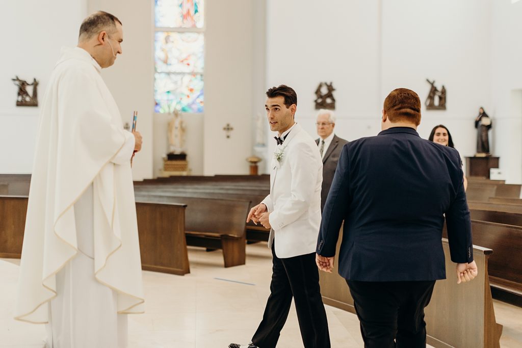 Groom talking with priest before Ceremony