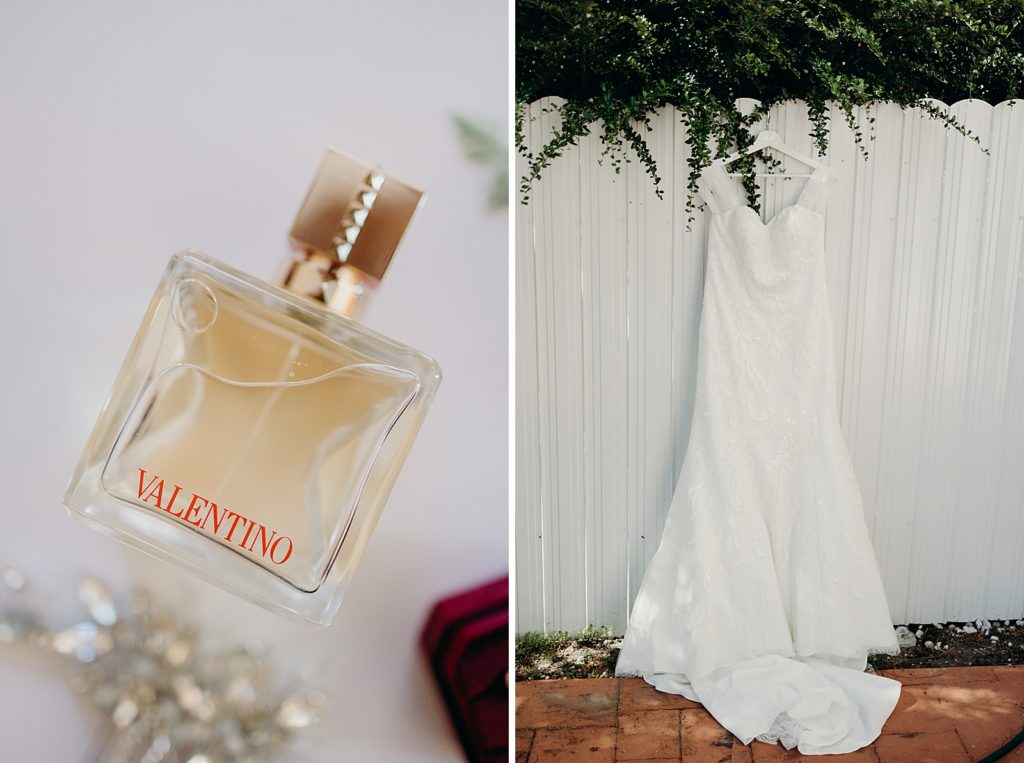 Detail shot of perfume bottle and wedding dress hanging on fence
