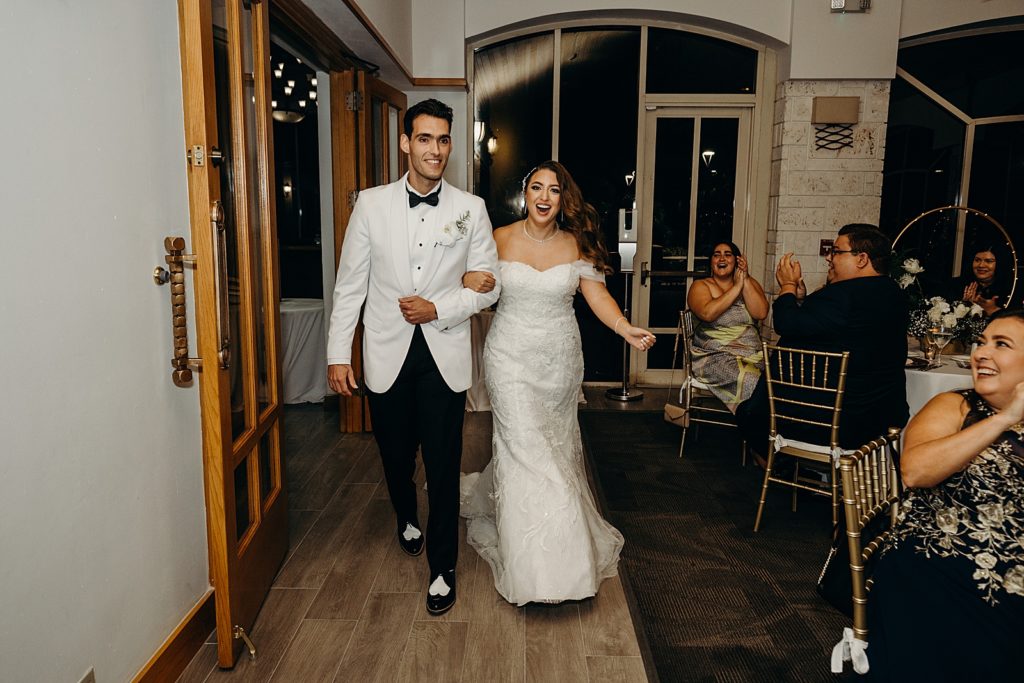 Bride and Groom arm in arm entering Reception together for nighttime Reception