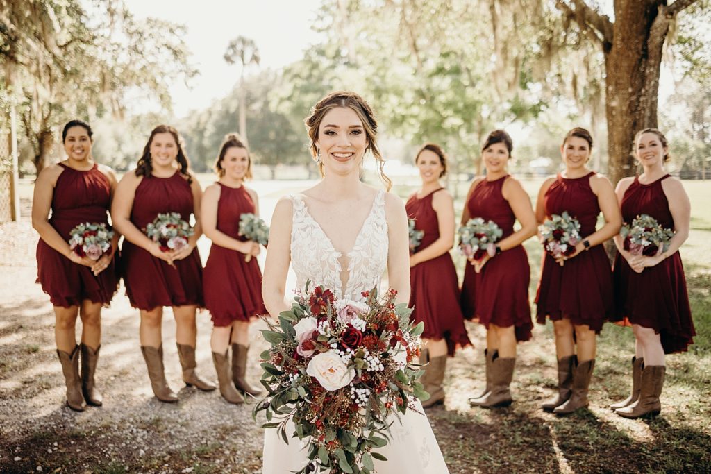 Bride with red bouquet with Bridesmaids behind her