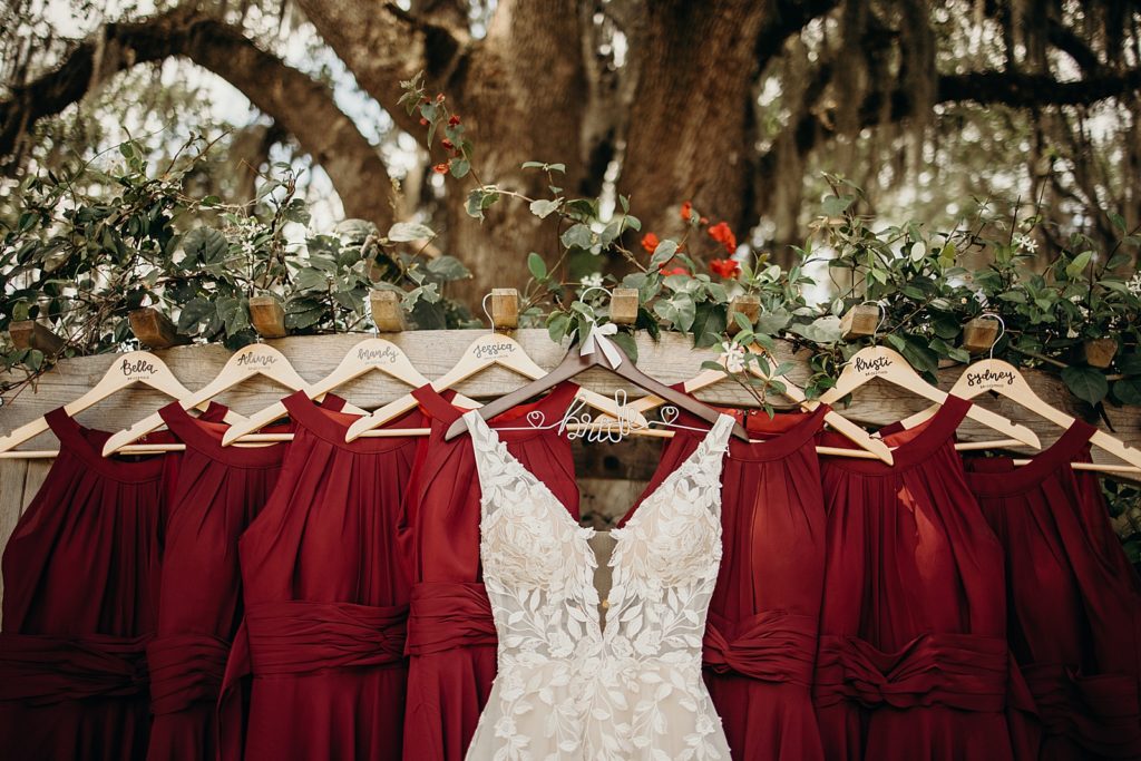 Detail shot of wedding dress and Bridesmaid dresses hanging outside by tree