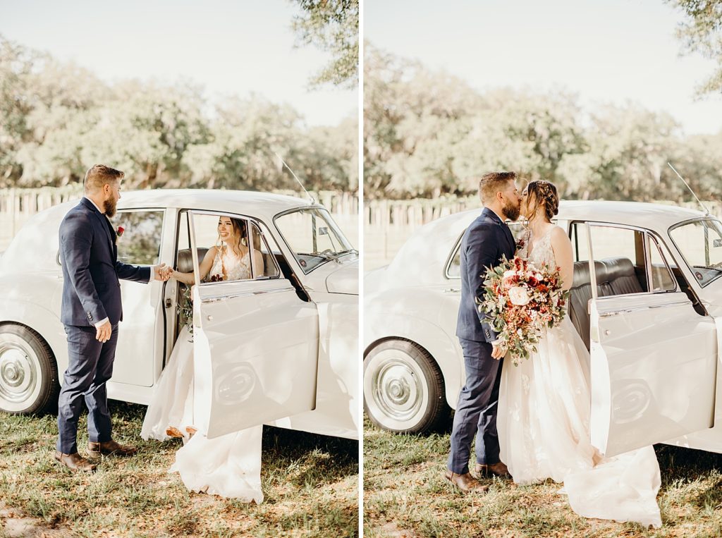 Groom helping Bride exit classic car and kissing her