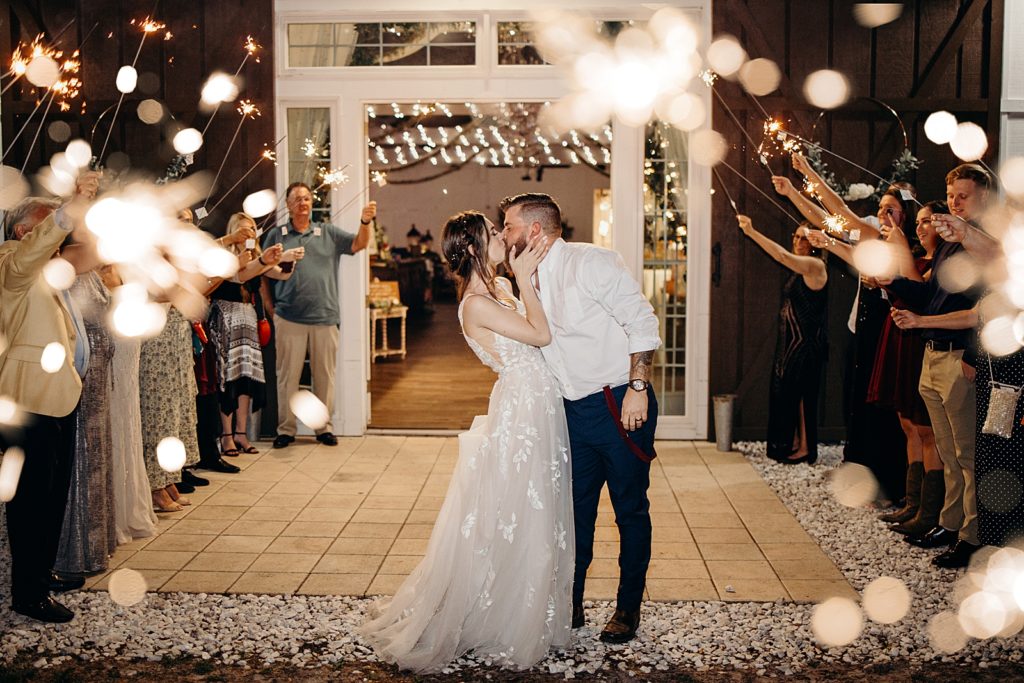 Bride and Groom kissing during nighttime sparkler exit
