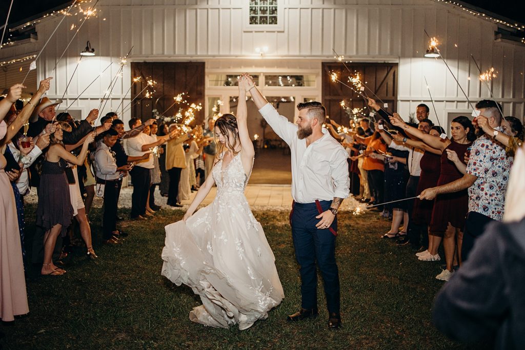 Bride twirling by Groom's hand during sparkler exit