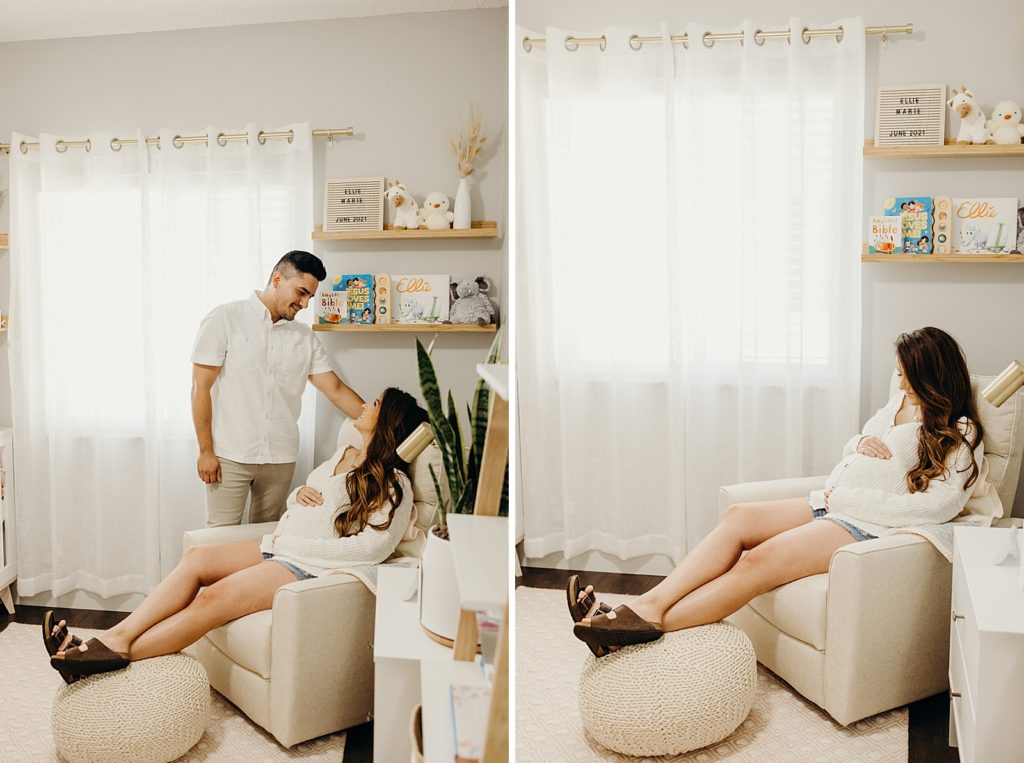Pregnant woman sitting in white chair in baby room with man standing next to her looking at her