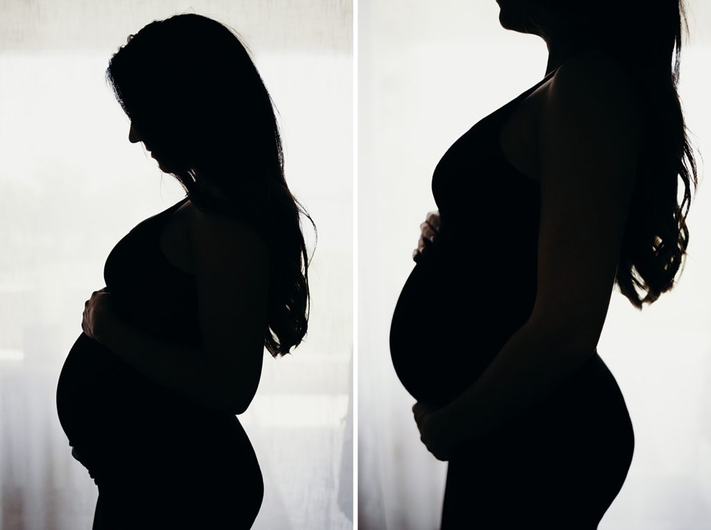 Silhouette of pregnant woman holding her stomach 