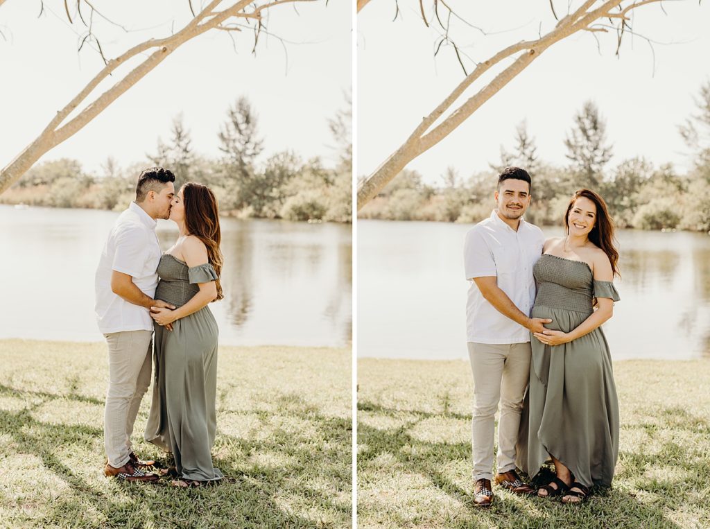 Pregnant couple holding pregnant stomach and kissing