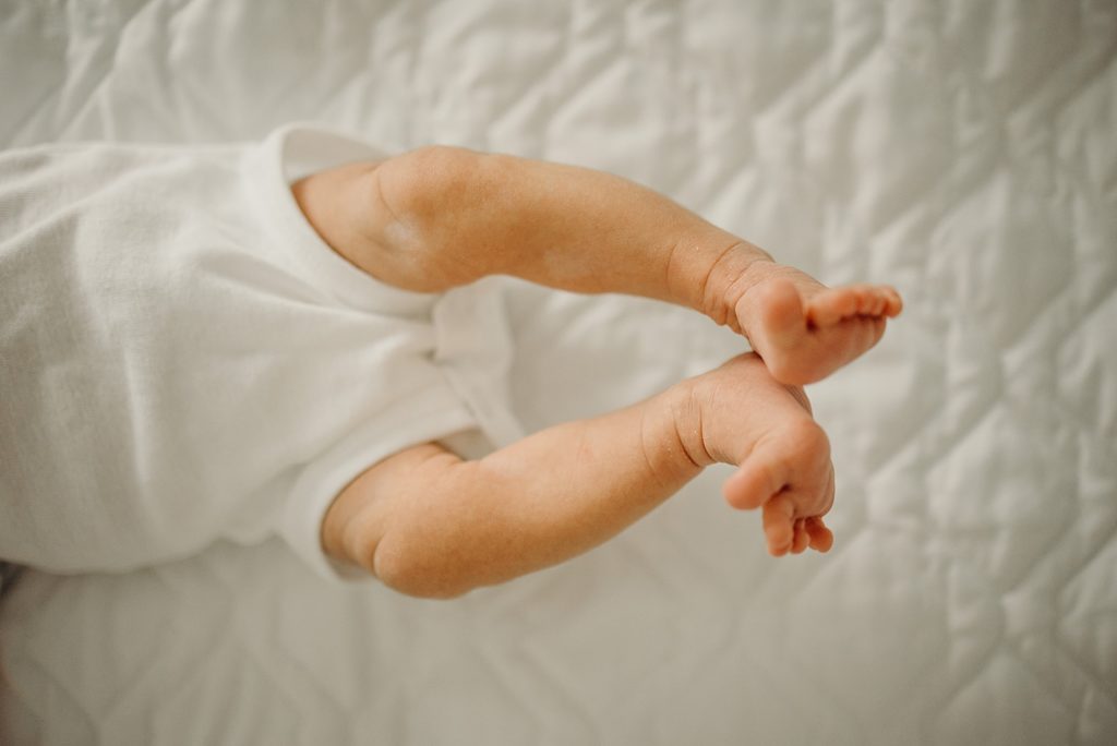 Closeup of baby's feet up in the air as toddler is laying down