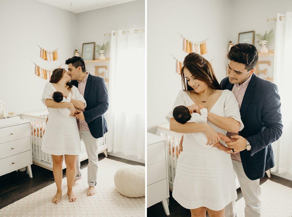Couple holding each other and kissing as Mother holds their child in baby room