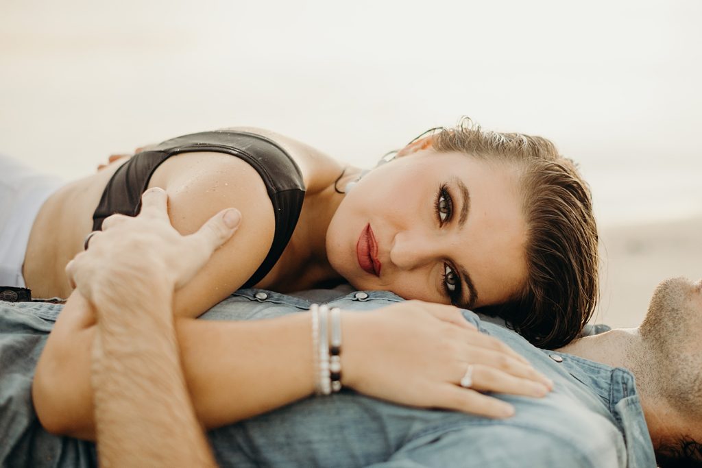 Closeup of woman laying on man's chest on the beach