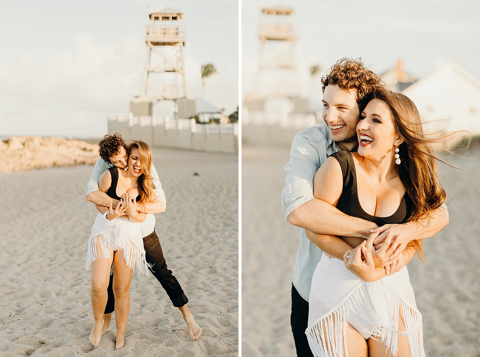 Man hugging woman from behind and kissing her neck while they stand on the sand of the beach with lighthouse stand behind them
