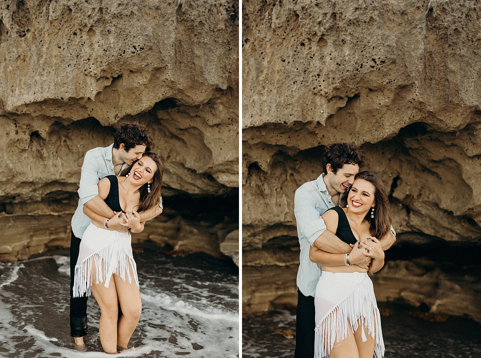 Man holding woman from behind and nuzzling side of her forehead next to naturally rock formation by the wet sand