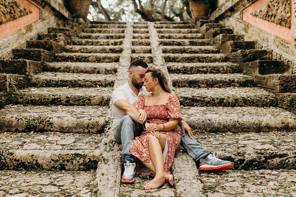 Couple sitting and nuzzling up on coarse staircase